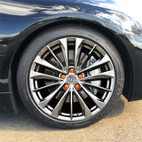 ColorLugs orange colored lug covers on silver automobile wheel